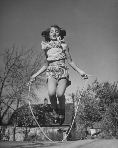 retro photo. girl skipping on a roap.