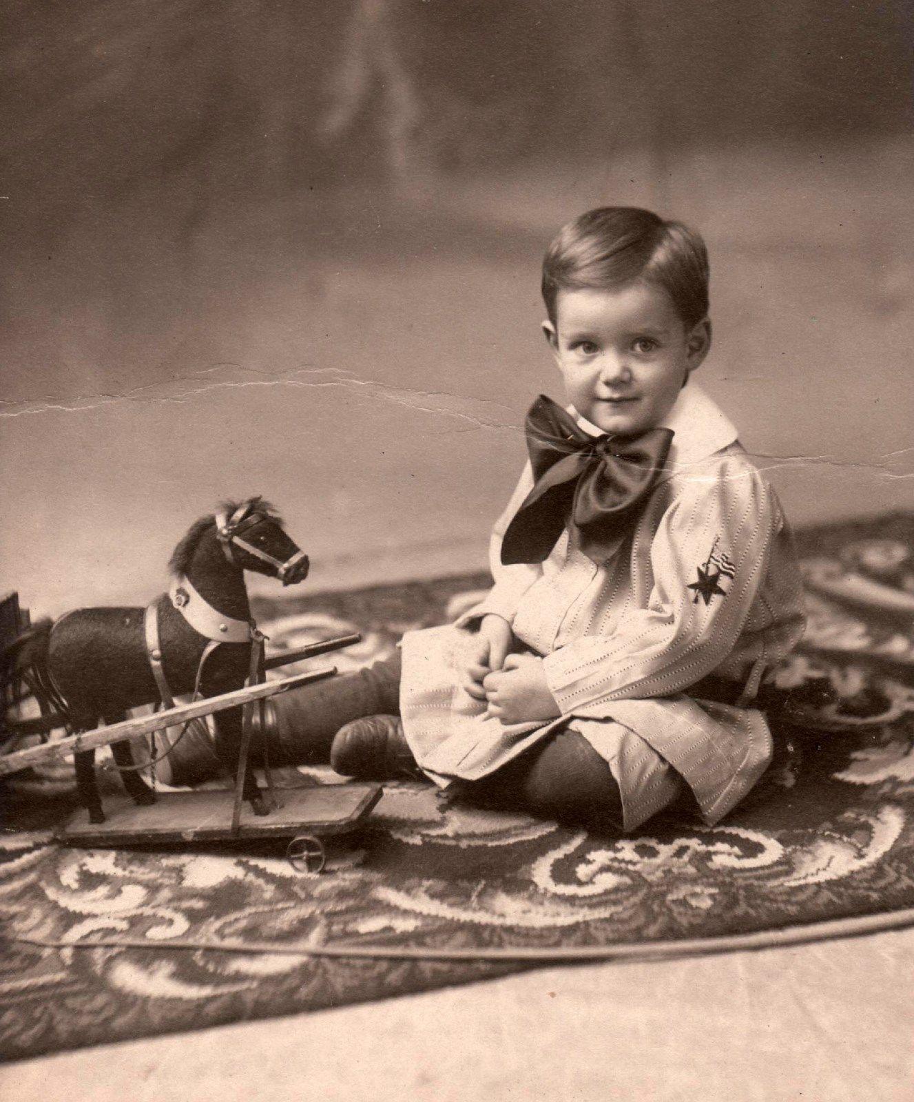 A boy with a vintage toy horse