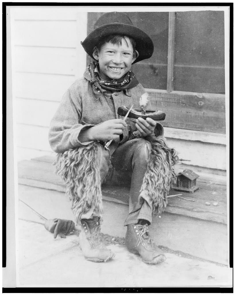 Vintage photo of native american boy with a toy