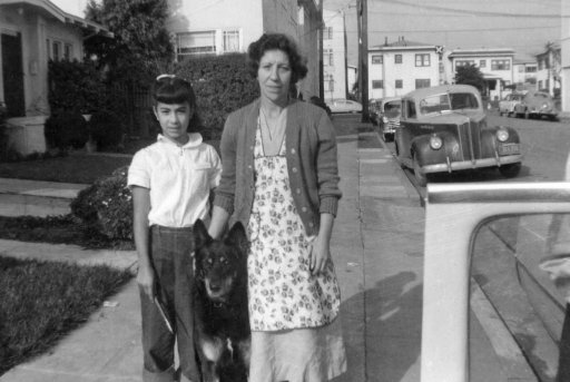 Old photo of a woman, girl and a dog on the street in 1950s