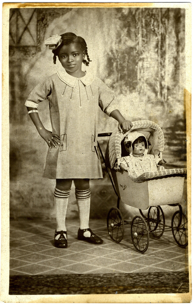 Vintage photo: afroamerican girl with her doll.
