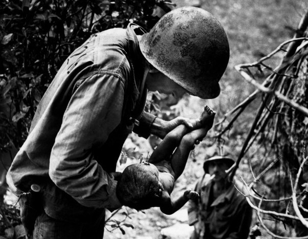 US marine holding a wounded Japanese kid during WW2