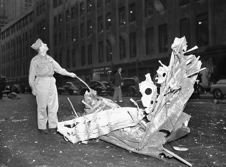 A man hovers over a piece debris from the B-25 Bomber near 33rd Street. July 28, 1945.
