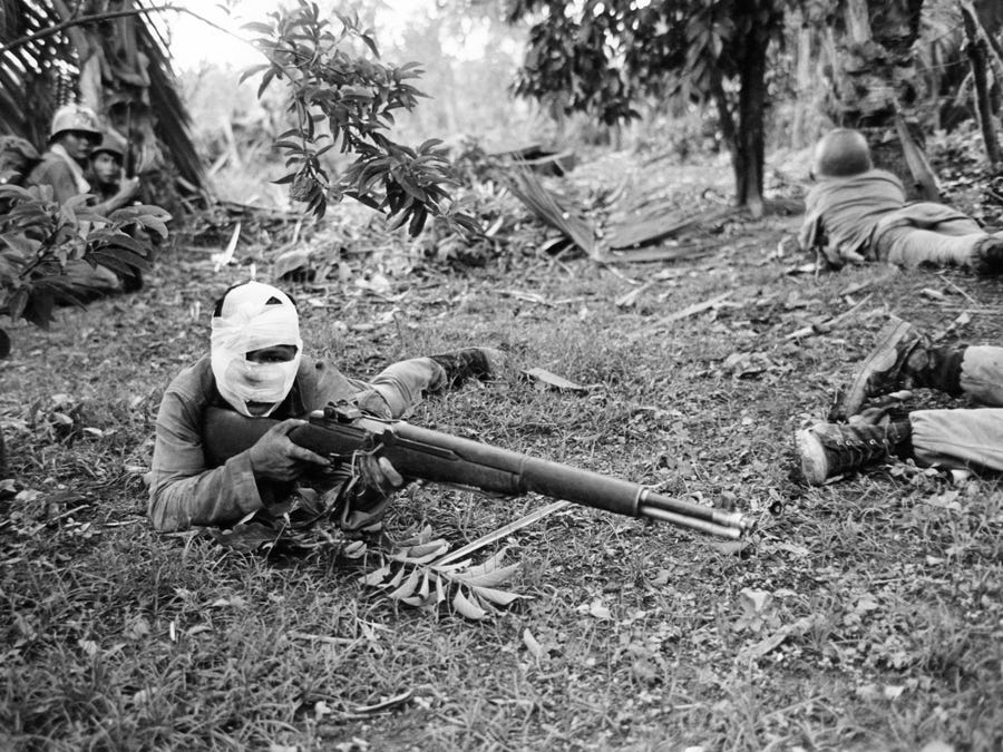 A wounded Vietnamese ranger is ready with his weapon to answer a Viet Cong attack during battle in Dong Xoai on June 11, 1965.