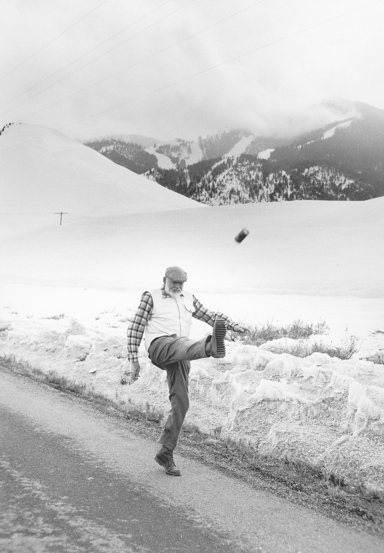 Hemingway kicking an alcohol bottle