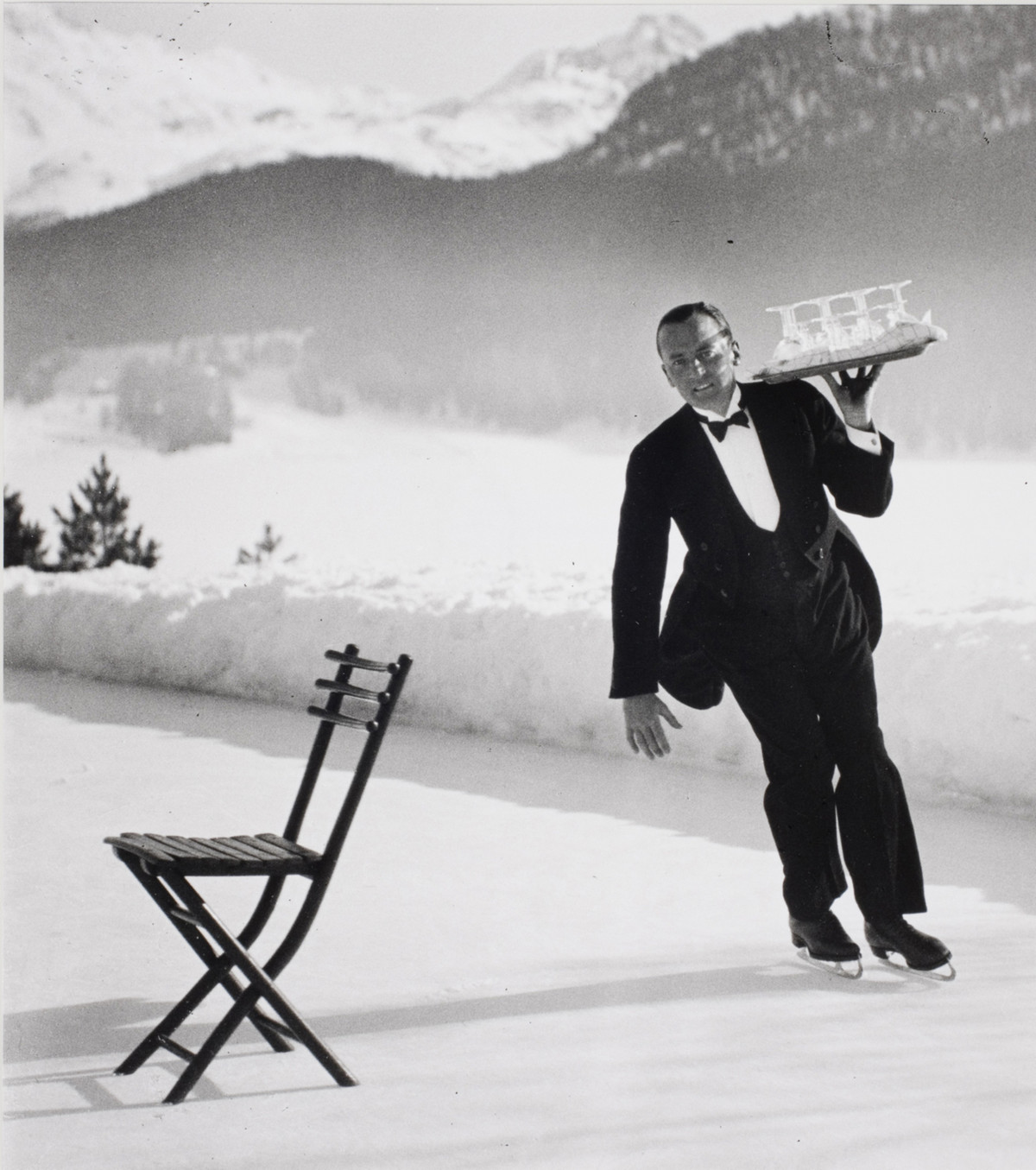 Senior waiter René Breguet from the Grand Hotel serving ice skating cocktails. The commune of St. Moritz in Switzerland, 1932.