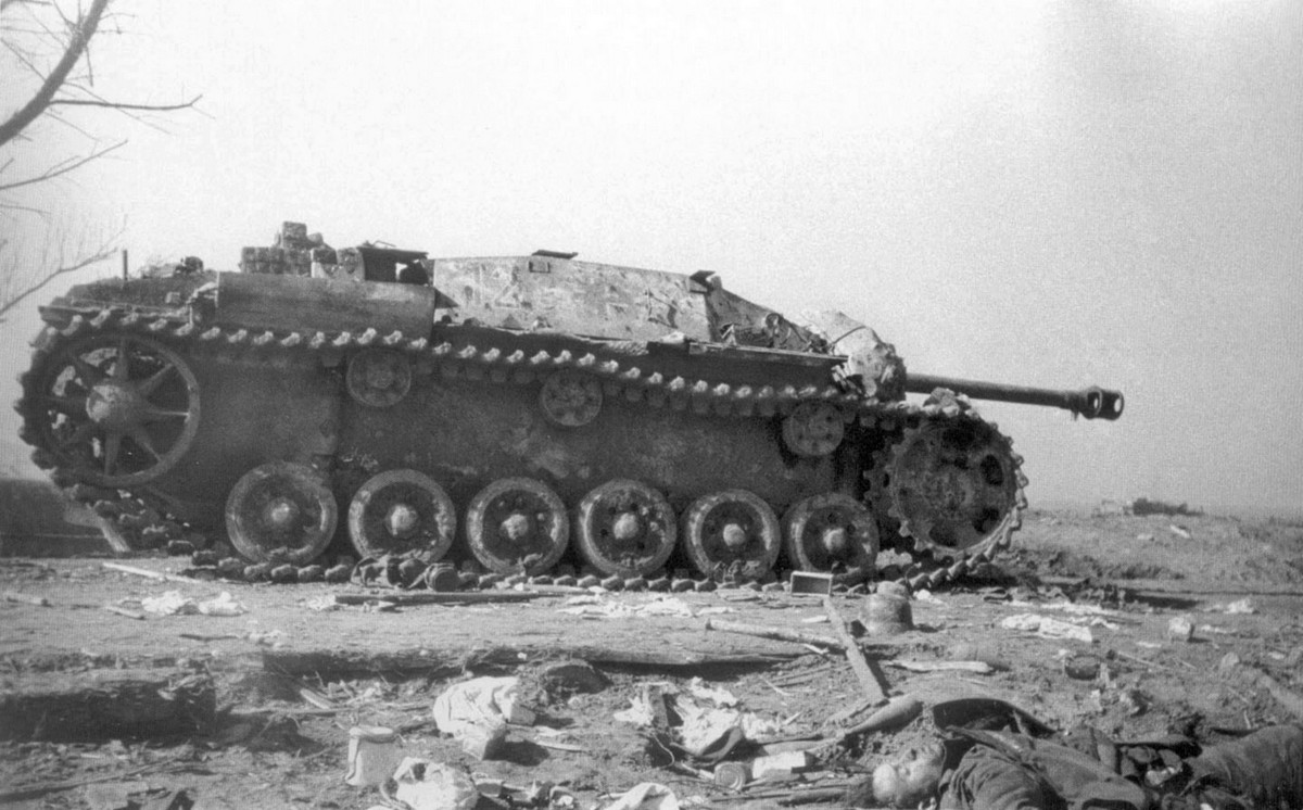 The StuG III assault gun knocked out in Konigsberg and the killed German soldier. Germany (1945)